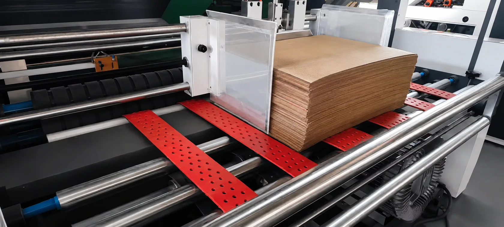 Pila de láminas de cartón corrugado en el sistema alimentador de una laminadora KIT